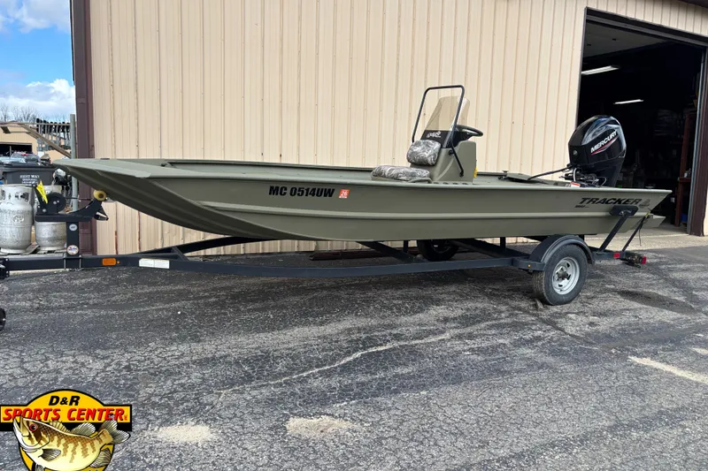 Slide: The Image of 2023 Tracker Grizzly 1860 CC boat on trailer outside a garage. - 2