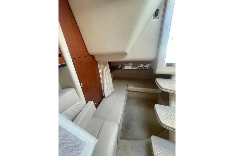 Slide: The Image of Interior cabin of 2003 Sea Ray 300 Sundancer with beige seating and wooden accents. - 10