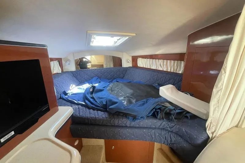 Slide: The Image of Interior cabin of a 2003 Sea Ray 300 Sundancer with bed and TV. - 13