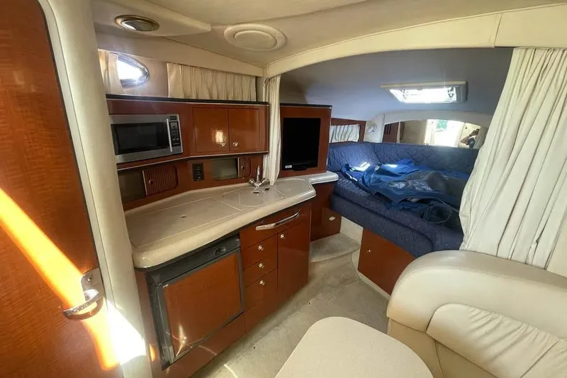 Slide: The Image of Interior of 2003 Sea Ray 300 Sundancer yacht with kitchenette and seating area. - 14