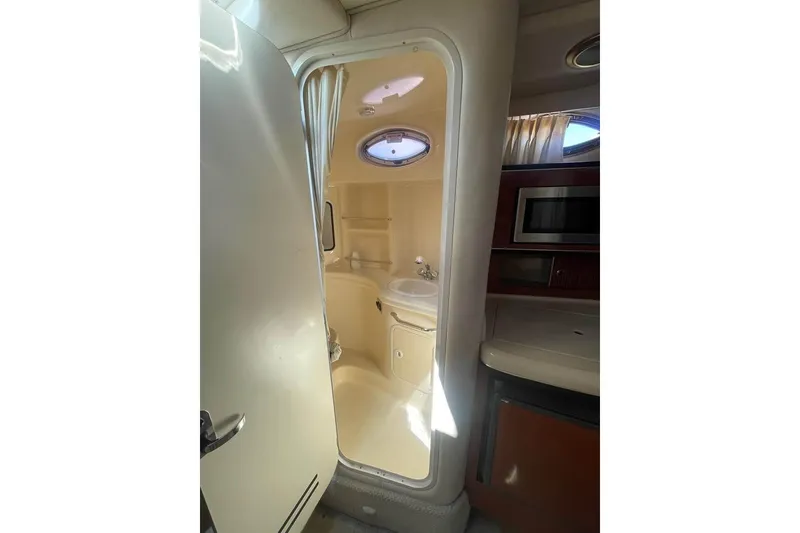 Slide: The Image of Interior view of 2003 Sea Ray 300 Sundancer bathroom with sink and porthole window. - 15