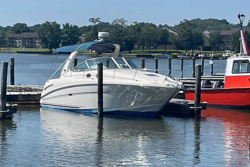 Slide: The Image of 2003 Sea Ray 300 Sundancer docked at a marina, calm water, clear sky. - 2