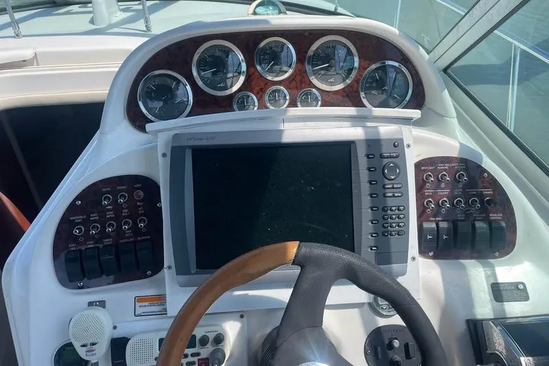 Slide: The Image of Helm of 2003 Sea Ray 300 Sundancer with gauges and navigation controls. - 3