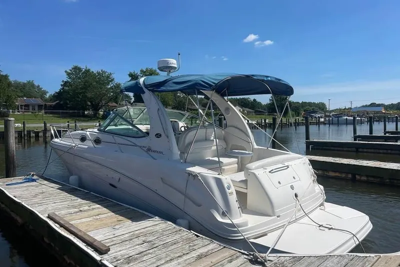 Slide: The Image of 2003 Sea Ray 300 Sundancer docked at a marina under a clear blue sky. - 4