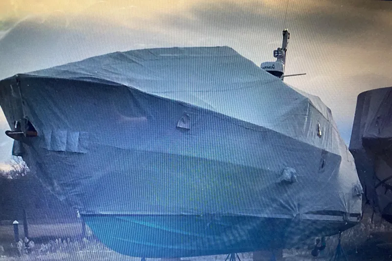 Slide: The Image of Covered Bluestar 29.9 boat from 2001, parked outdoors under cloudy sky. - 41