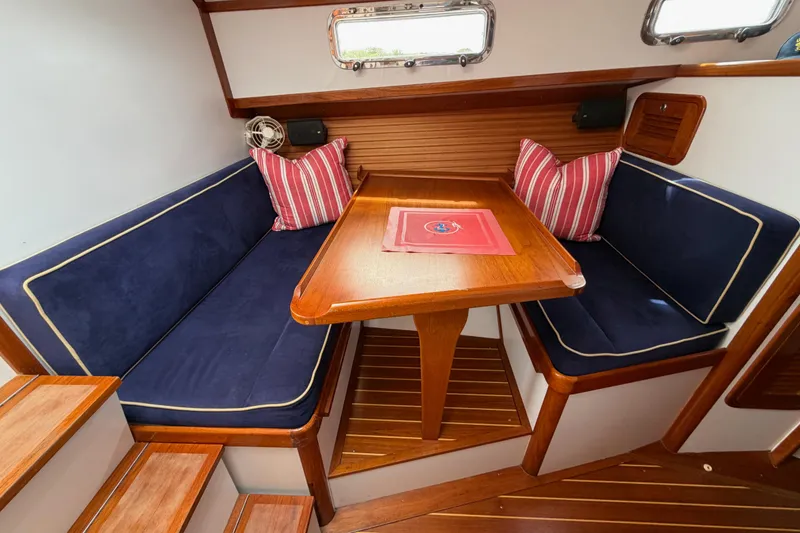 Slide: The Image of Cozy dining area in 2001 Bluestar BlueStar 29.9 boat with wooden table and navy cushions. - 16