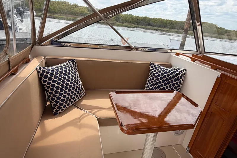 Slide: The Image of Cozy seating area on 2001 Bluestar BlueStar 29.9 boat with patterned cushions and wooden table. - 9
