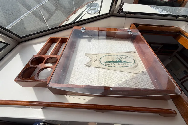 Slide: The Image of Wooden boat interior with a display case and cup holders, featuring a Guilford, Connecticut flag. - 11