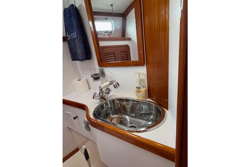 Slide: The Image of Compact bathroom sink area in 2001 Bluestar BlueStar 29.9 boat with wooden accents. - 29