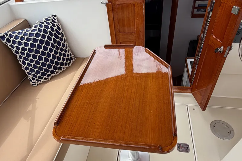Slide: The Image of Interior of 2001 Bluestar BlueStar 29.9 boat with polished wooden table and cushioned seating. - 10