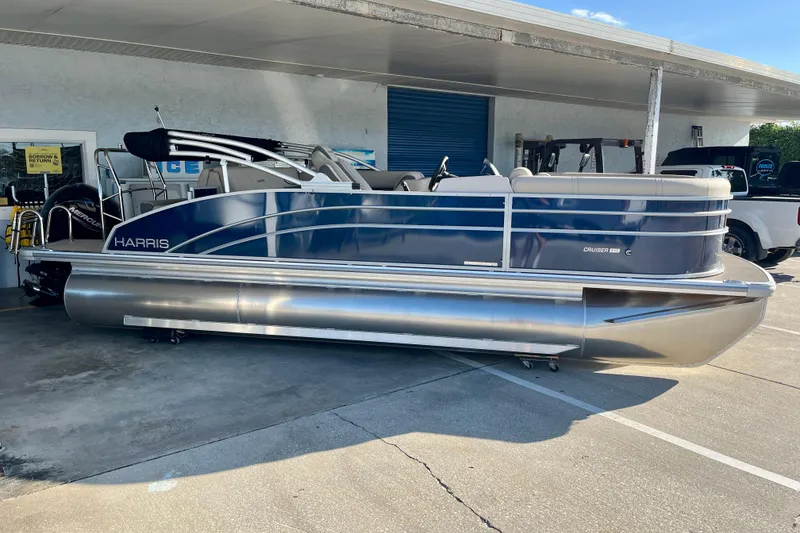 Slide: The Image of 2026 Harris Cruiser 210 pontoon boat in a showroom. - 2