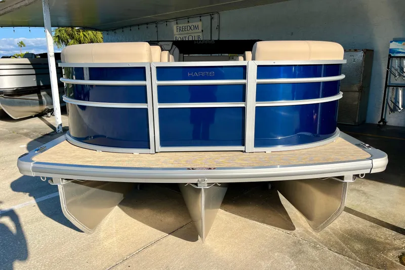 Slide: The Image of 2026 Harris Cruiser 210 pontoon boat in blue, front view. - 1