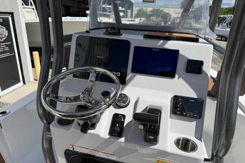 Slide: The Image of 2026 Sea Pro 230 Bay boat dashboard with steering wheel and navigation controls. - 14