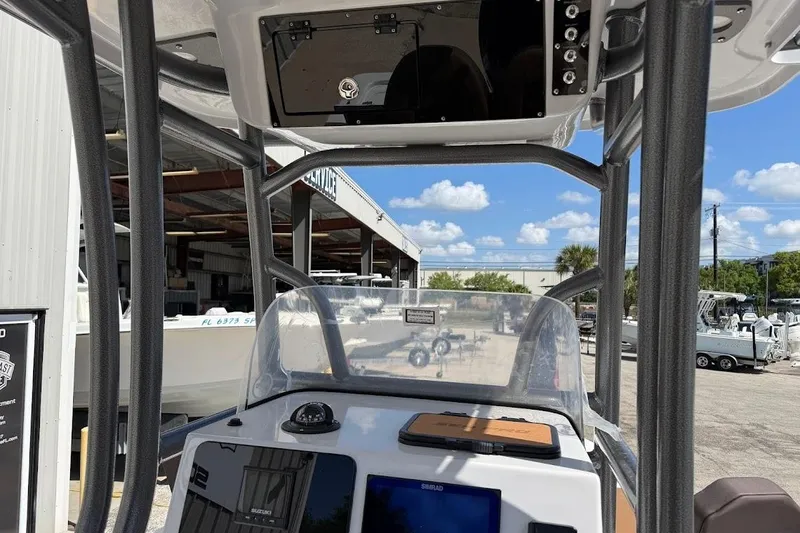 Slide: The Image of 2026 Sea Pro 230 Bay boat console with electronics, docked under clear blue sky. - 15