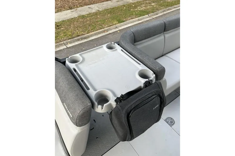 Slide: The Image of 2023 Bombardier Sea Doo interior with table and cup holders on gray seating. - 14