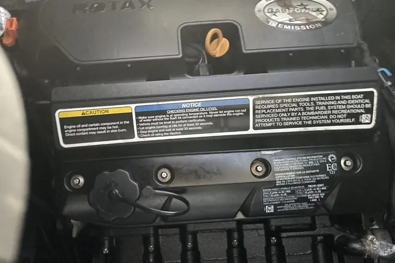 Slide: The Image of 2023 Bombardier Sea Doo engine compartment with caution and service labels visible. - 18