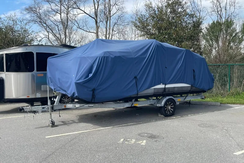 Slide: The Image of Covered 2023 Bombardier Sea Doo on trailer in parking lot, next to an RV. - 3
