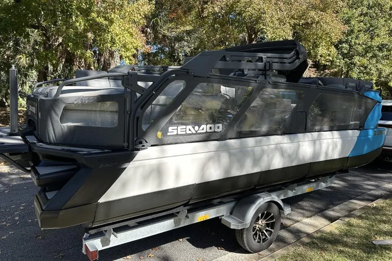 Slide: The Image of 2023 Bombardier Sea Doo on trailer, parked outdoors with trees in background. - 4