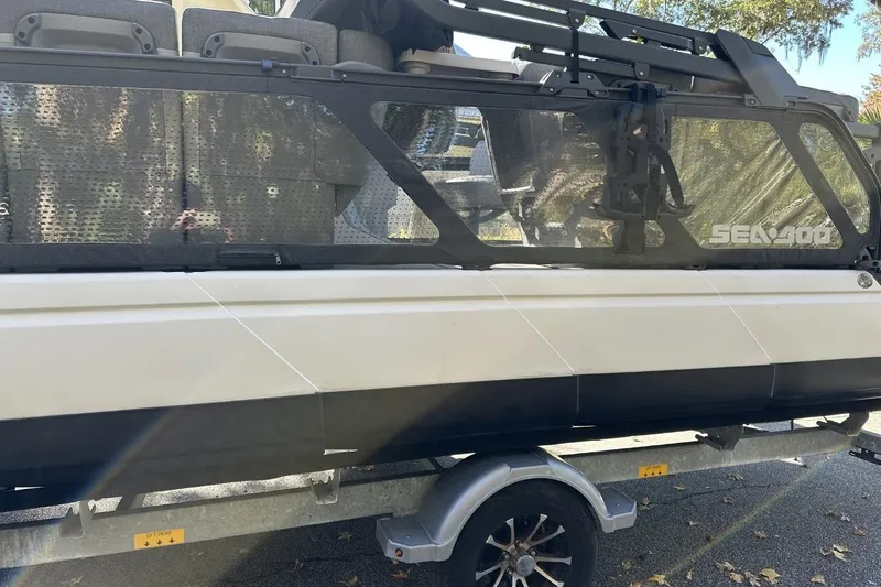 Slide: The Image of 2023 Bombardier Sea Doo on trailer, side view with visible seating and windows. - 5