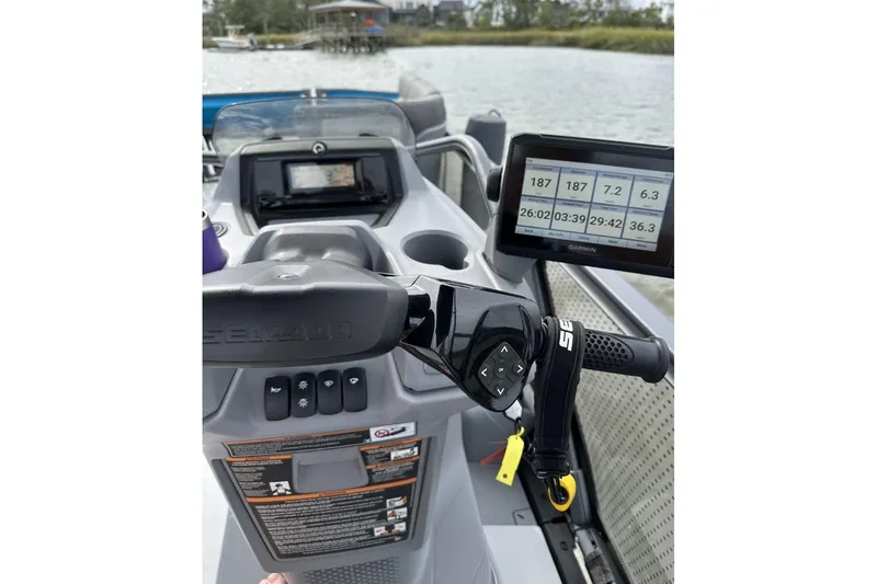 Slide: The Image of 2023 Bombardier Sea Doo dashboard with digital display and controls on water. - 8