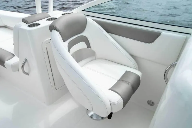 Slide: The Image of Manufacturer Provided Image: 2026 World Cat 230 SD boat interior with white and gray seating, cup holders, and water view. - 15