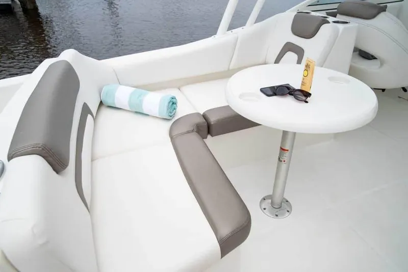 Slide: The Image of Manufacturer Provided Image: Interior of 2026 World Cat 230 SD boat with seating, table, towel, and sunglasses. - 17