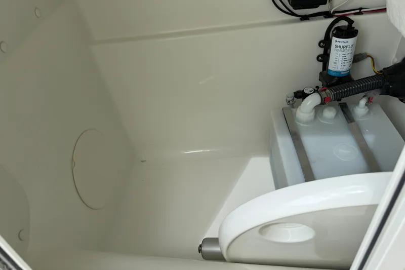 Slide: The Image of Interior view of 2026 World Cat 230 SD boat compartment with pump and tank system. - 25