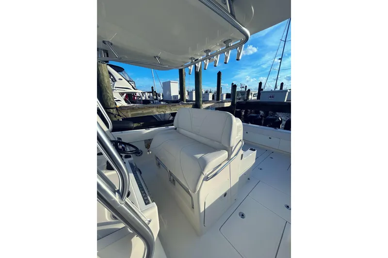 Slide: The Image of 2020 SeaVee 370Z boat interior with white seating at a marina dock. - 12
