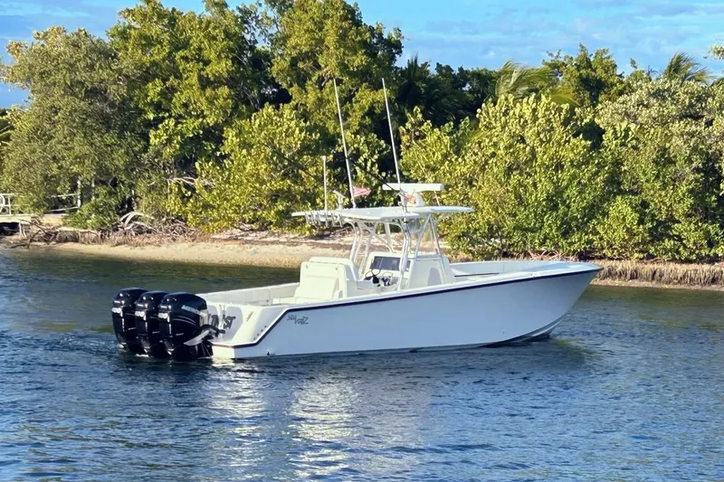 Slide: The Image of 2020 SeaVee 370Z boat with triple outboard motors on a calm waterway. - 6