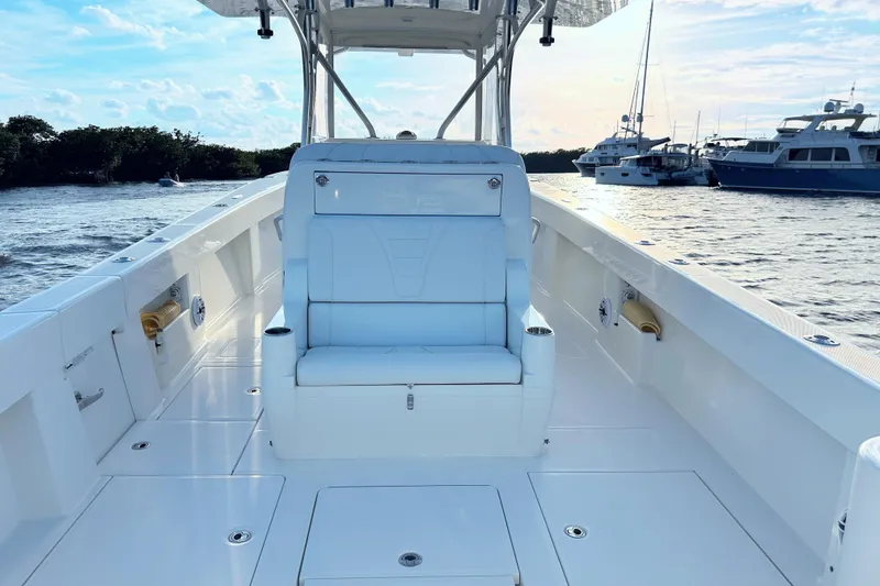 Slide: The Image of 2020 SeaVee 370Z boat interior with white seating, docked near other vessels. - 8