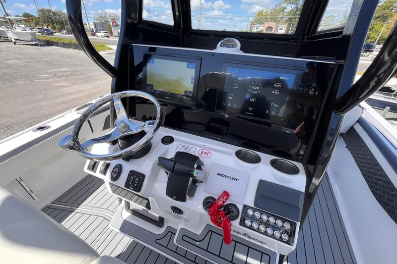 Slide: The Image of 2024 Tidewater 2700 Carolina Bay boat dashboard with steering wheel and digital displays. - 10