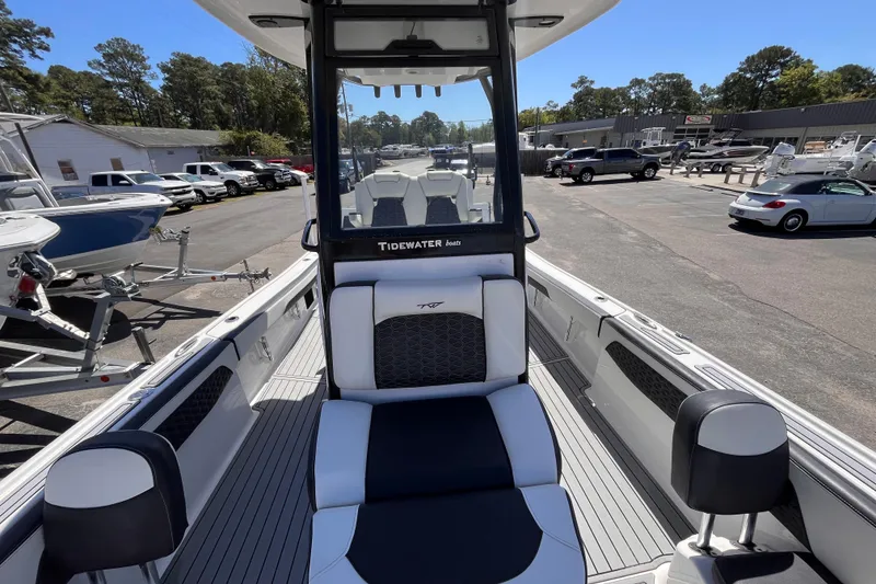 Slide: The Image of 2024 Tidewater 2700 Carolina Bay boat interior at a dealership, showcasing seating and console. - 13