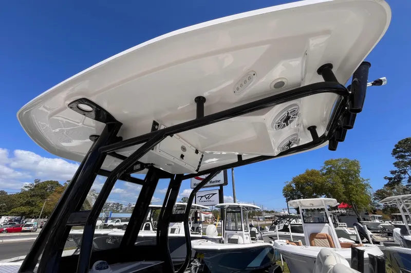 Slide: The Image of 2024 Tidewater 2700 Carolina Bay boat with T-top and speakers, displayed outdoors. - 16