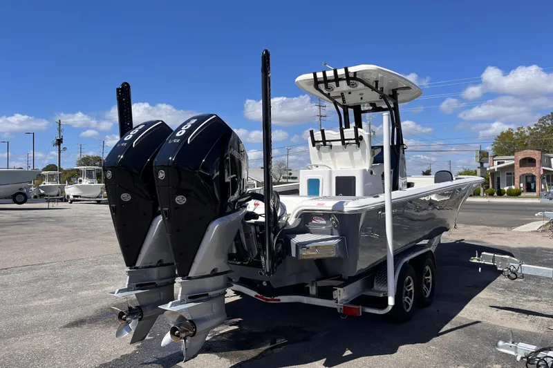 Slide: The Image of 2024 Tidewater 2700 Carolina Bay boat with dual engines on a trailer, under a clear blue sky. - 4