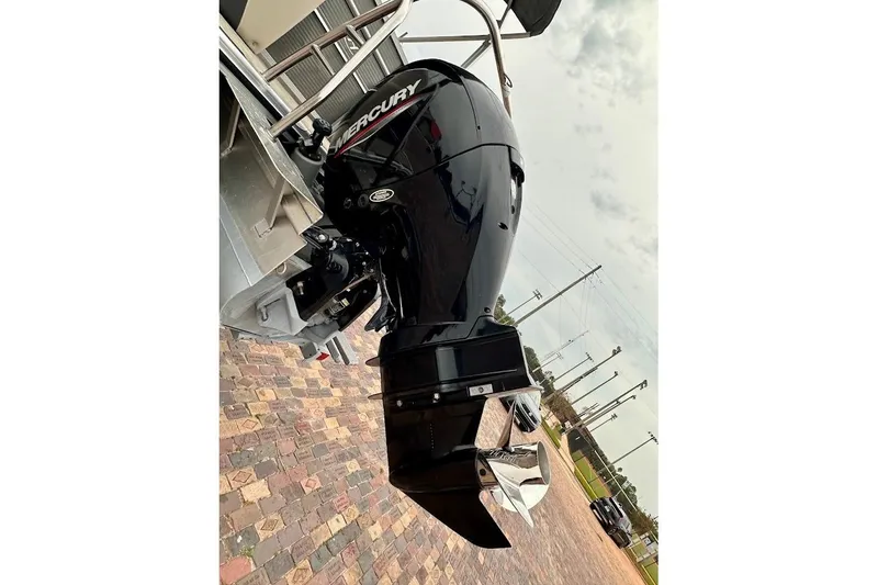 Slide: The Image of 2023 Harris Cruiser 230 with Mercury outboard motor on a brick-paved surface. - 13