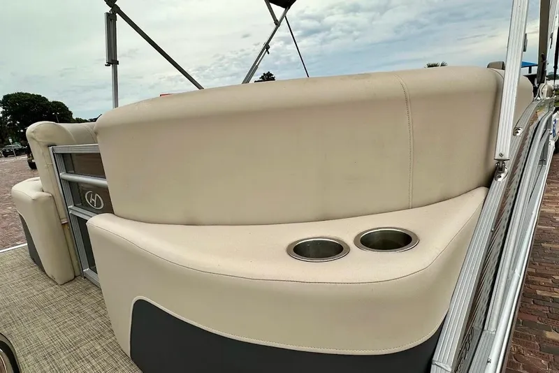 Slide: The Image of 2023 Harris Cruiser 230 boat interior with beige seating and cup holders. - 16