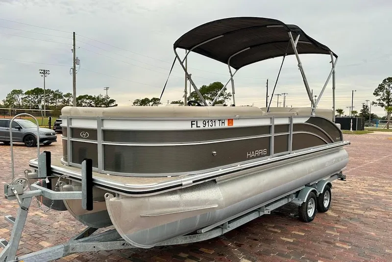 Slide: The Image of 2023 Harris Cruiser 230 pontoon boat on trailer in parking lot. - 4