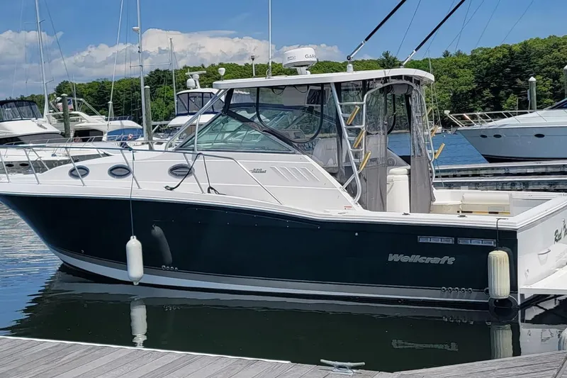 The Image of 2006 Wellcraft 330 Coastal boat docked at marina under clear blue sky. - 1
