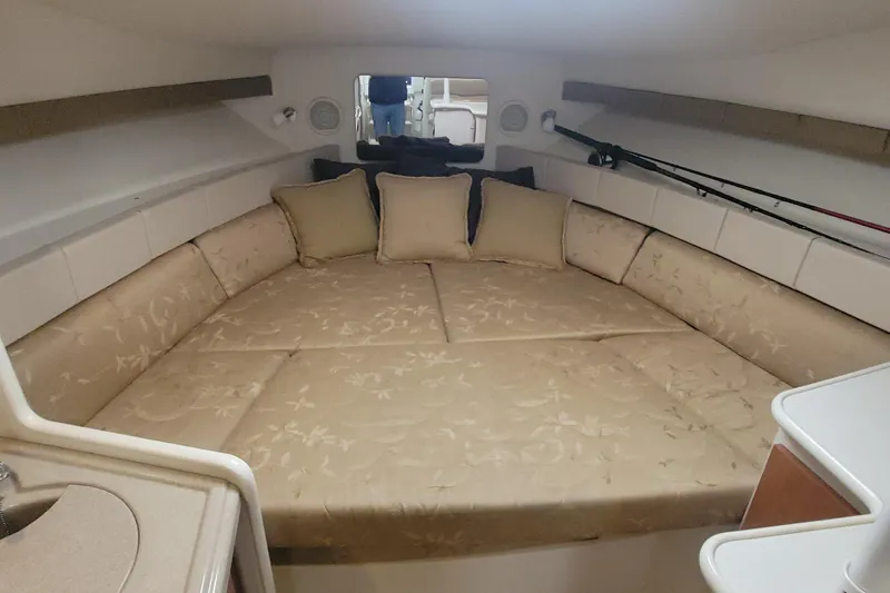 Slide: The Image of Interior cabin of 2006 Wellcraft 330 Coastal boat with beige cushions and fishing rods. - 11