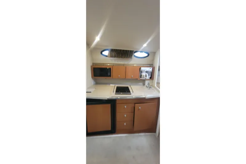 Slide: The Image of 2006 Wellcraft 330 Coastal boat kitchen with microwave, stove, and sink. - 13
