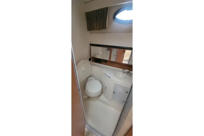 Slide: The Image of 2006 Wellcraft 330 Coastal boat bathroom with toilet, sink, and mirror. - 14