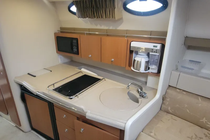 Slide: The Image of Compact kitchen area in a 2006 Wellcraft 330 Coastal boat with appliances and storage. - 16