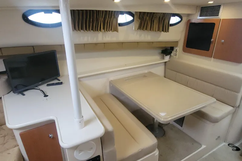 Slide: The Image of 2006 Wellcraft 330 Coastal cabin interior with dining area and TV setup. - 17