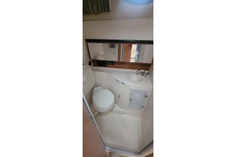 Slide: The Image of 2006 Wellcraft 330 Coastal boat bathroom with toilet, sink, and mirror. - 18