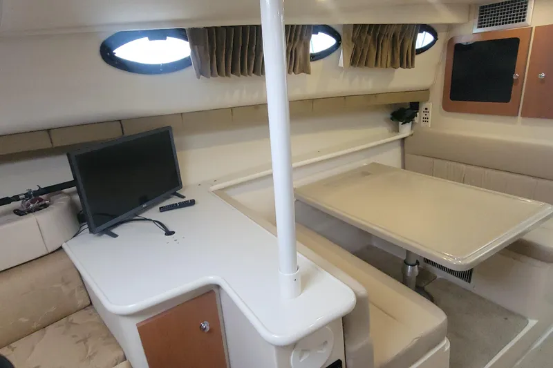Slide: The Image of 2006 Wellcraft 330 Coastal cabin interior with table, seating, and mounted TV. - 21