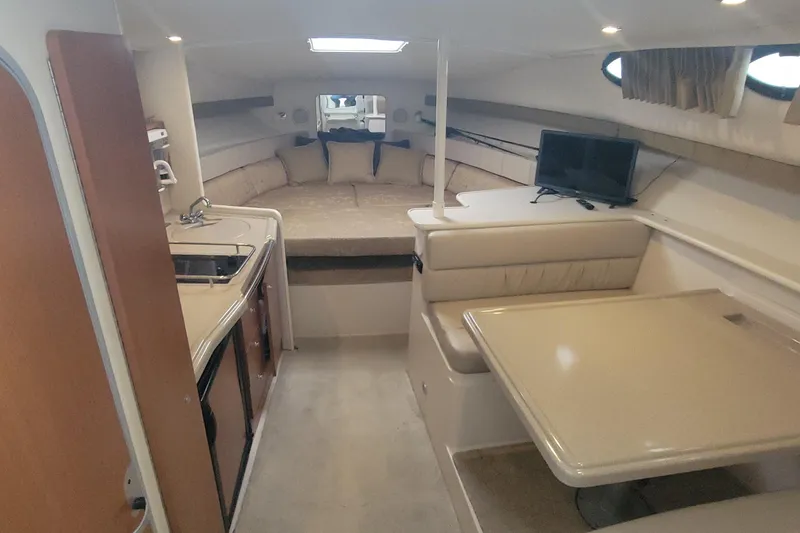 Slide: The Image of 2006 Wellcraft 330 Coastal cabin interior with kitchenette, seating, and bed. - 8