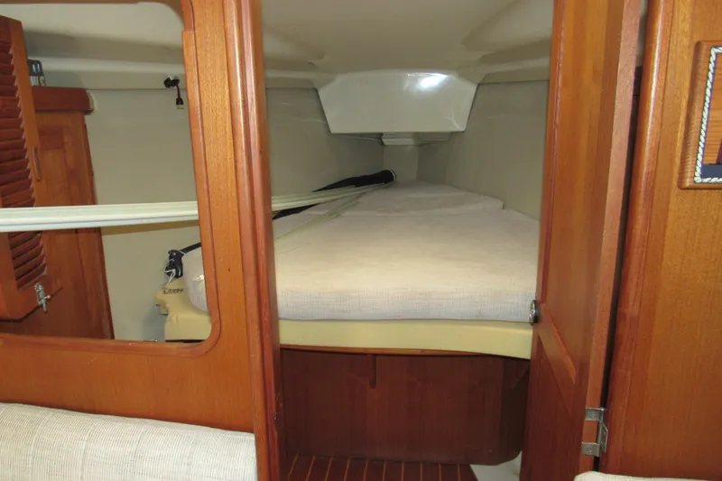 Slide: The Image of Cabin interior of 1991 Marlow-Hunter 37.5 sailboat with wooden finishes and cozy bedding. - 10