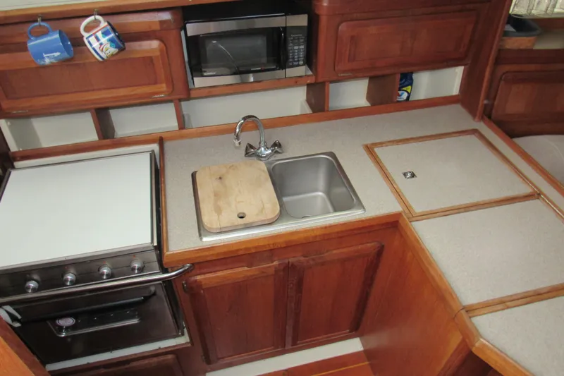 Slide: The Image of 1991 Marlow-Hunter 37.5 yacht kitchen with stove, sink, and wooden cabinetry. - 8