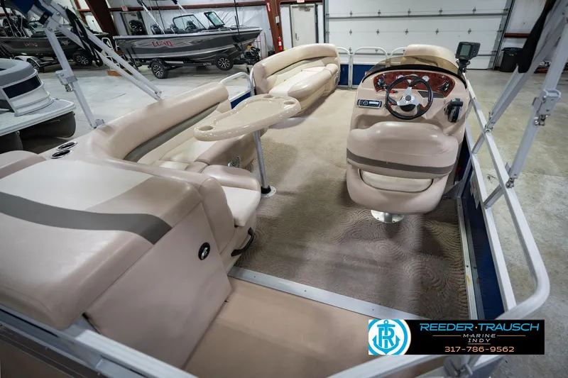 Slide: The Image of 2014 Sun Tracker Party Barge 20 DLX interior with beige seating and steering console. - 14