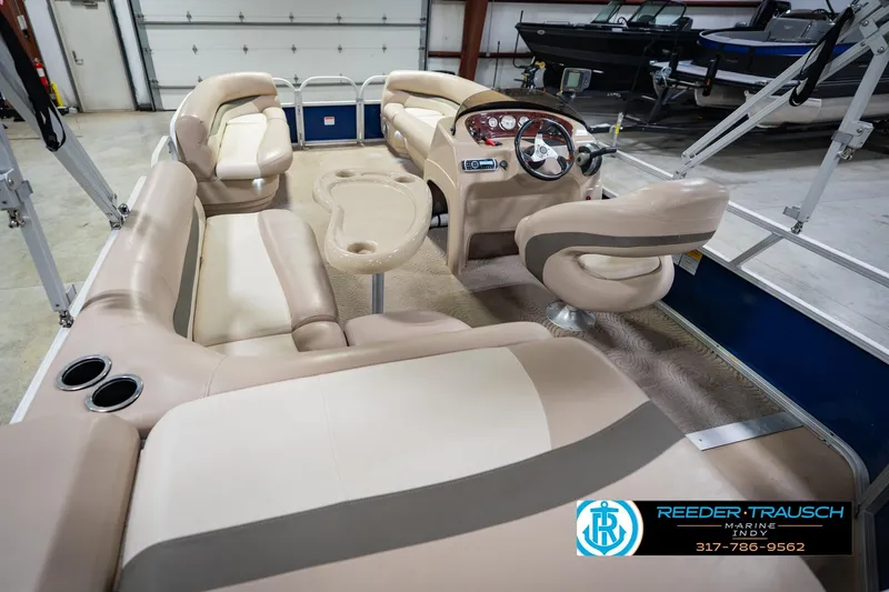 Slide: The Image of 2014 Sun Tracker Party Barge 20 DLX interior with beige seating and steering console. - 15